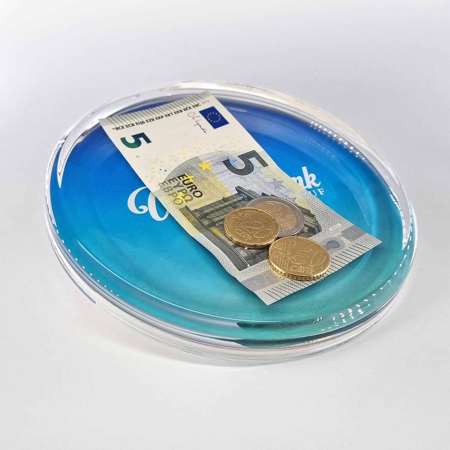 Blauer Glaszahlteller mit Geldschein und Münzgeld