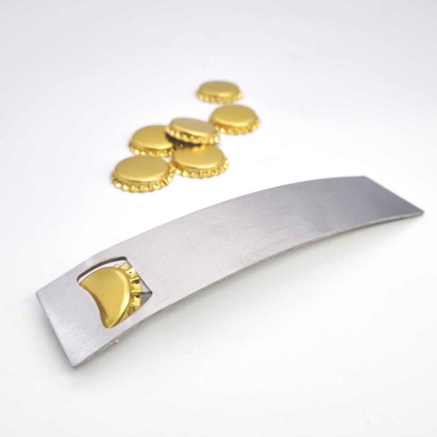 Flaschenöffner aus Edelstahl im Einsatz mit goldenen Kronkorken