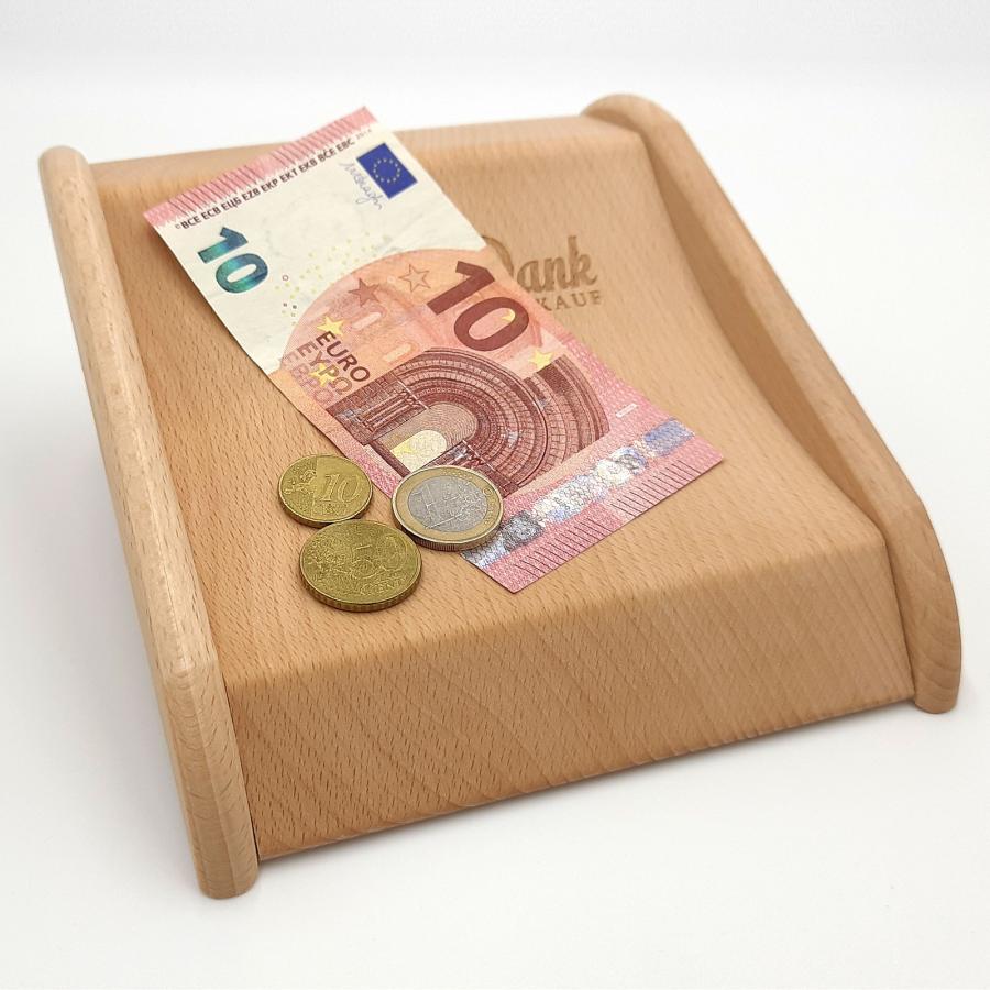 Ein Holzzahlteller mit einem 10 Euroschein und Münzen